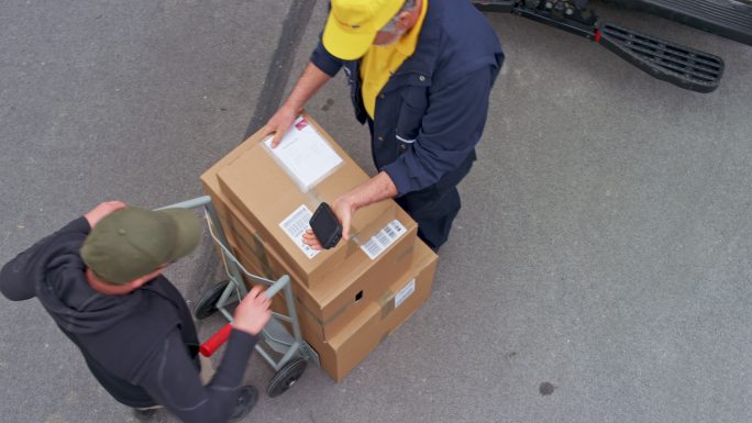 CS高级送货员从货车上取下包裹，客户签字