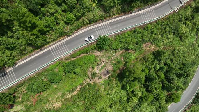 白色汽车行驶在山路田中路上