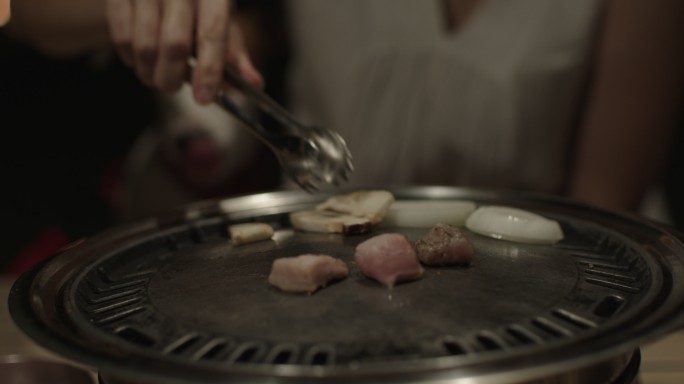 亚洲女人和杰克·拉塞尔梗犬吃烧烤鸡肉烤架