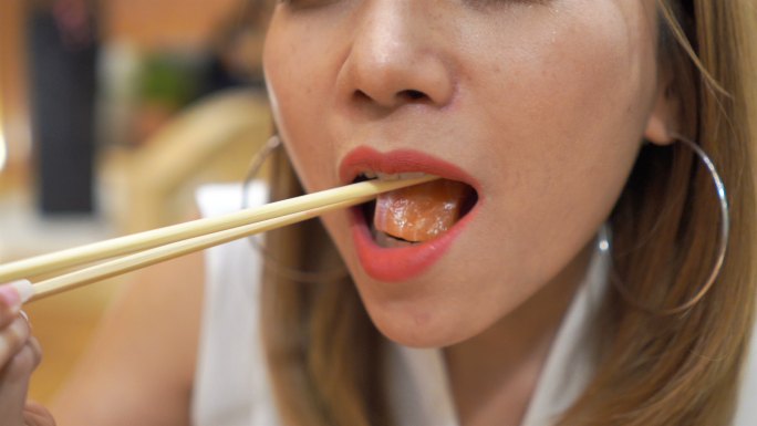 日本女性口吃鲑鱼-生鱼片的特写