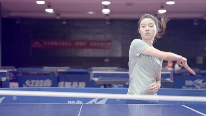 乒乓球馆里一个女孩儿在打乒乓球