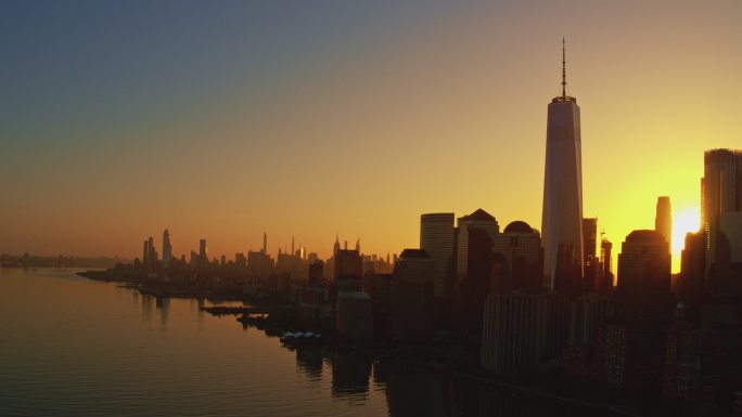 日出时分，从泽西市穿过哈德逊河欣赏曼哈顿的美景。带有电影式全景相机运动的空中镜头。