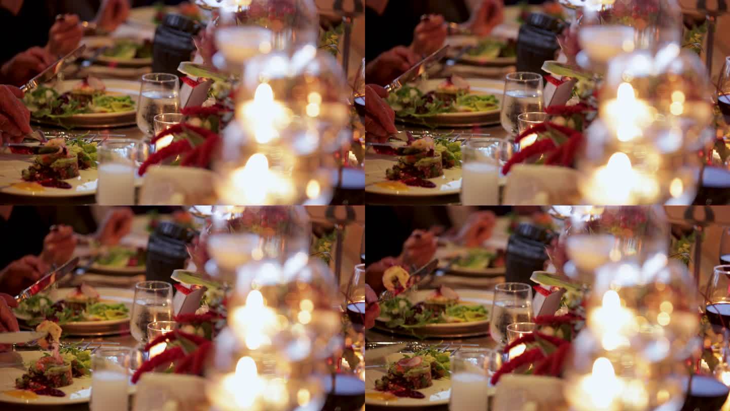美食。美食晚餐。客人在餐厅享用葡萄酒和晚餐。餐厅晚餐特写。晚餐在装饰好的桌子上。婚礼。