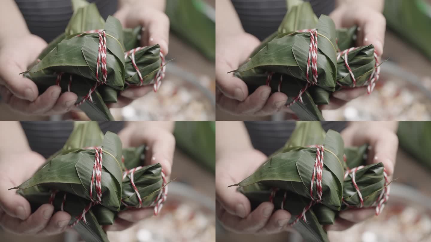 端午节端午节期间，一位亚洲老太太正忙着用米饭、肉、蛋包粽子，吃中国亚洲菜