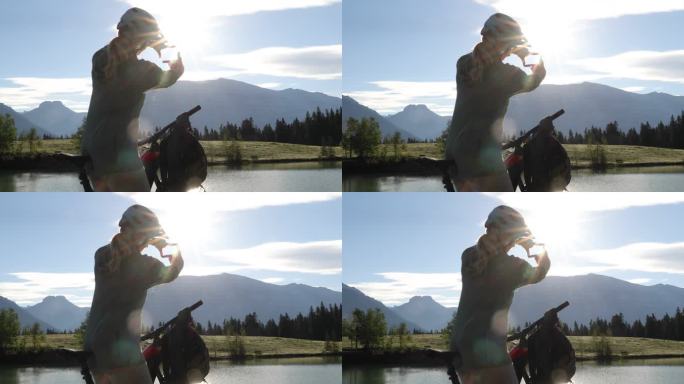 女子山地摩托车手在山湖边停下
