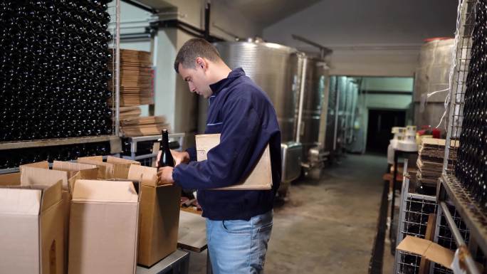 酿酒厂工人在酒窖中包装葡萄酒瓶