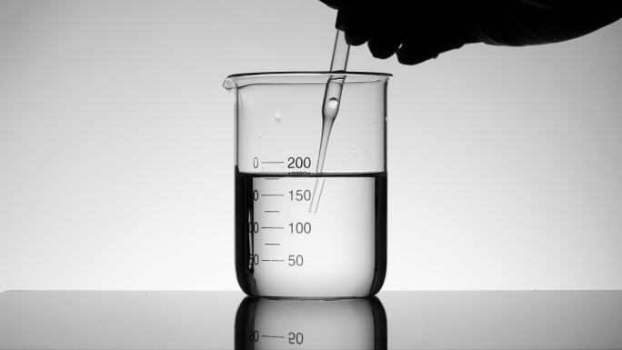 科学家使用滴管吸取烧杯中的液体