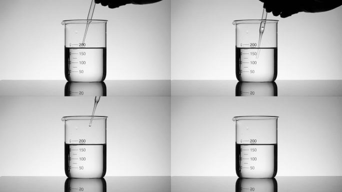 科学家使用滴管吸取烧杯中的液体