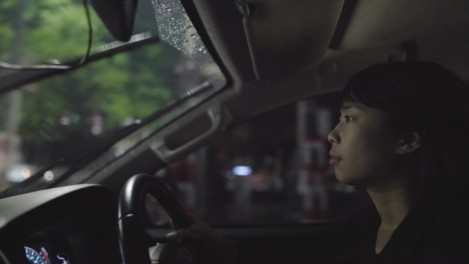 亚洲女性当我下班开车回家时，天正下着倾盆大雨。