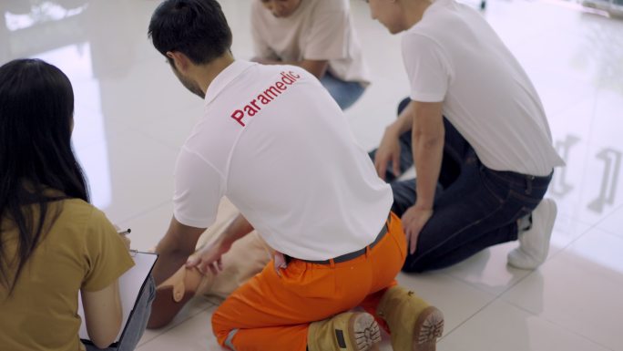 亚洲护理教练，一群学习在假人上练习CPR急救技术的人。