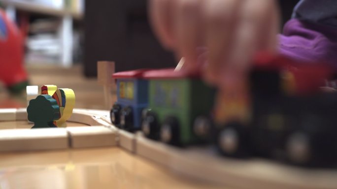 可爱的小女孩在玩木制火车