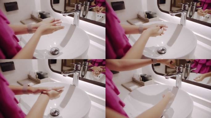 一位女士在酒店房间的洗脸盆前洗手。