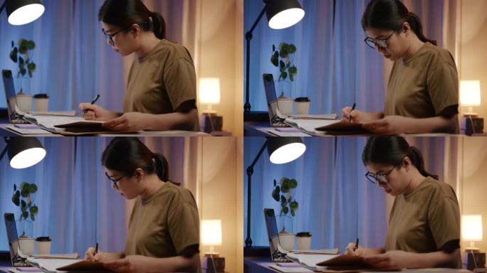 亚洲女性在家检查纸面工作账单