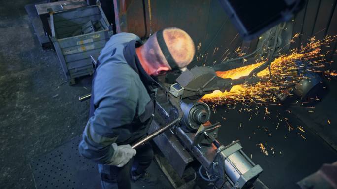 CS在铸造厂打磨金属铸件的男性工人