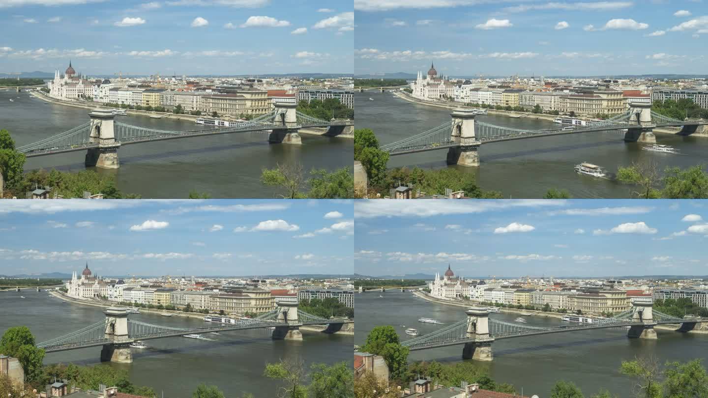 匈牙利议会和链桥周末繁忙，游客众多，匈牙利布达佩斯夏季交通拥堵，时间轴高角度侧视，缩小