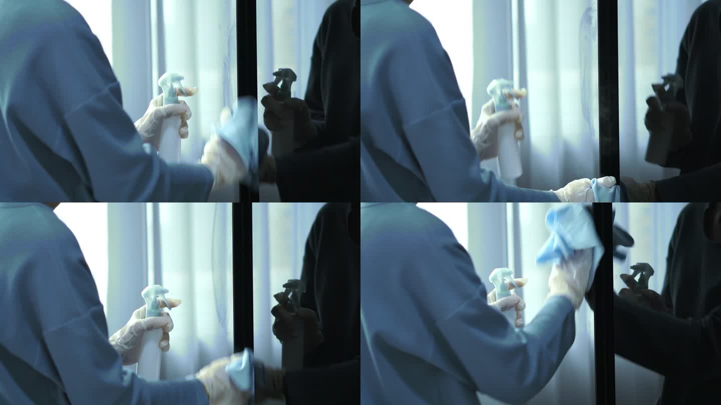 戴塑料手套的妇女在冰箱上喷洒酒精消毒剂，对表面进行细菌或病毒消毒