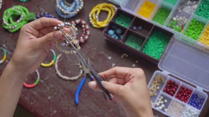 女性手工制作带有小球和石头的手工珠宝