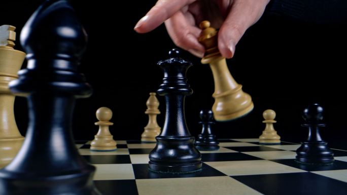 DS国际象棋比赛中，一名女性手拿着一个黑色皇后和她的白色皇后