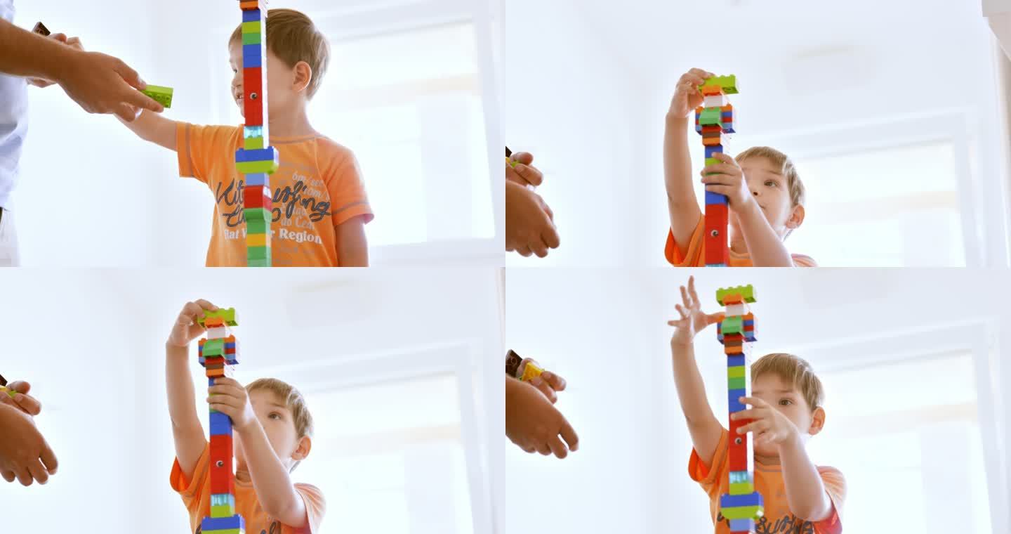 男孩和父亲一起建造了一座高塑料砖塔