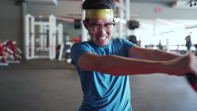 亚洲瘦子男子与粉色壶铃在健身房锻炼