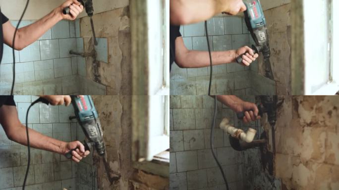 建筑商从浴室中移除旧瓷砖。拆除锤。