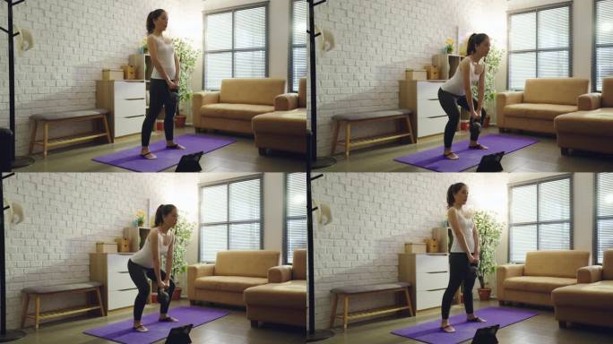 亚洲女性在家里沙发上锻炼。她蹲着