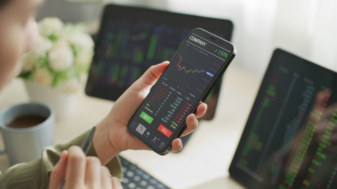 投资者在屏幕手机上查看股市数据