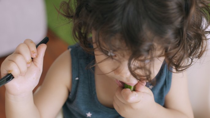 婴儿咬黄瓜的俯视图。