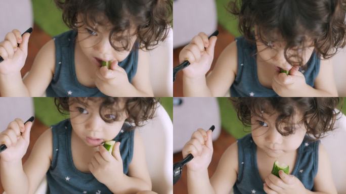 婴儿咬黄瓜的俯视图。