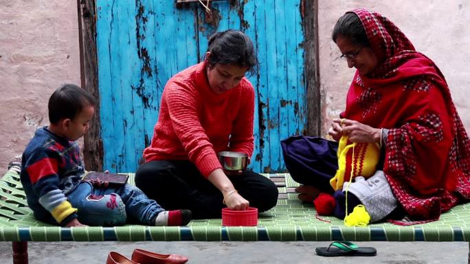 印度的家庭生活喂食手抓饭织毛衣