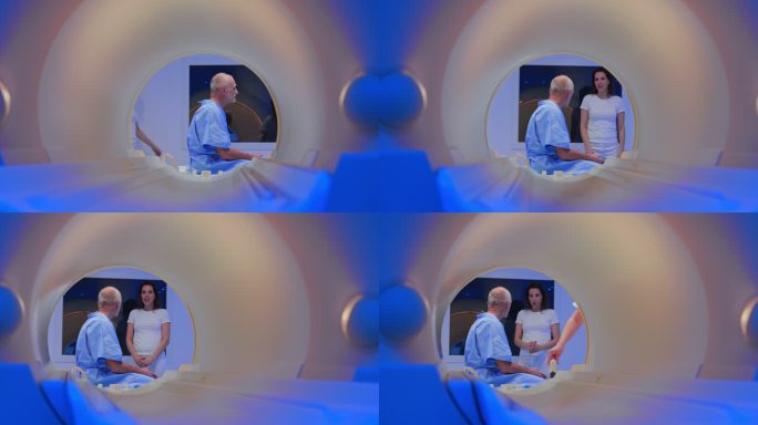 DS老年男性患者坐在MRI机器的桌子上，与男性医生交谈