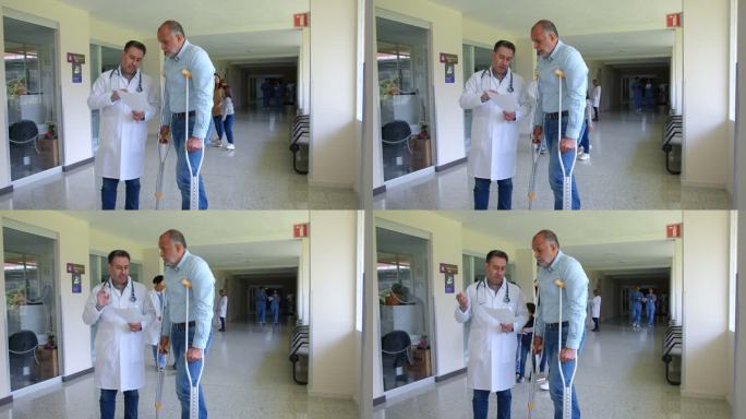 男性骨科医生一边用拐杖向年长的患者解释，一边给他看他的病历