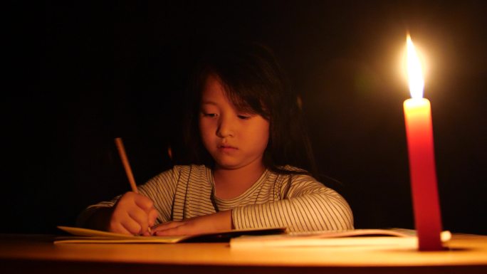 点蜡烛写作业停电小女孩烛光学习晚上