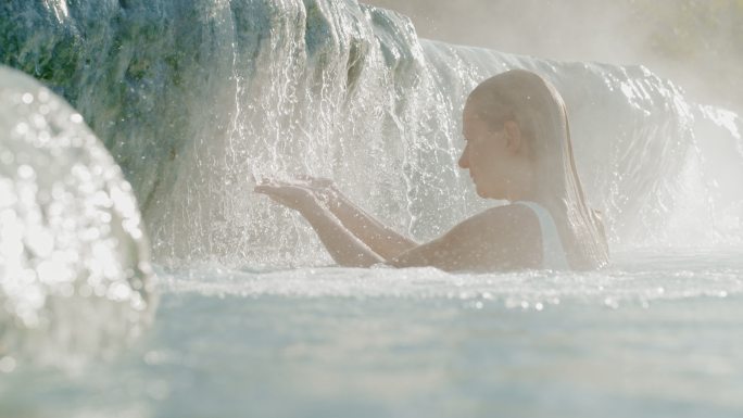 SUPER SLO MO女人在Saturnia温泉的天然泳池放松