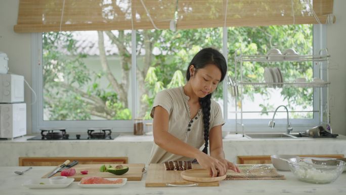 日本裔女厨师在木盘上摆放寿司