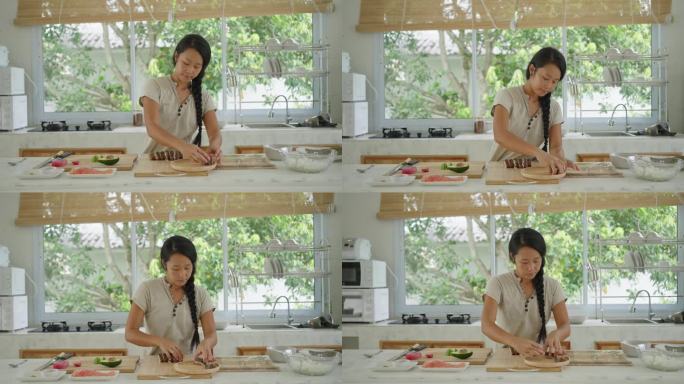 日本裔女厨师在木盘上摆放寿司