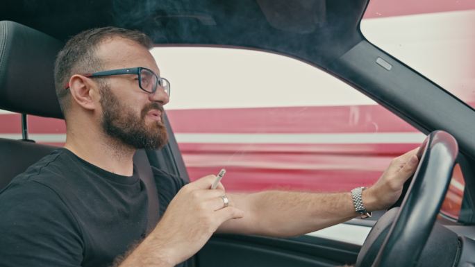 男子驾驶和吸烟开车抽烟
