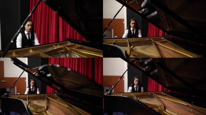 一位年轻而有才华的钢琴家在剧院练习大钢琴演奏技巧。