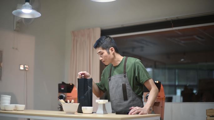 专业亚洲男中式咖啡师准备咖啡杯在明亮的房间里用磅秤称取样品