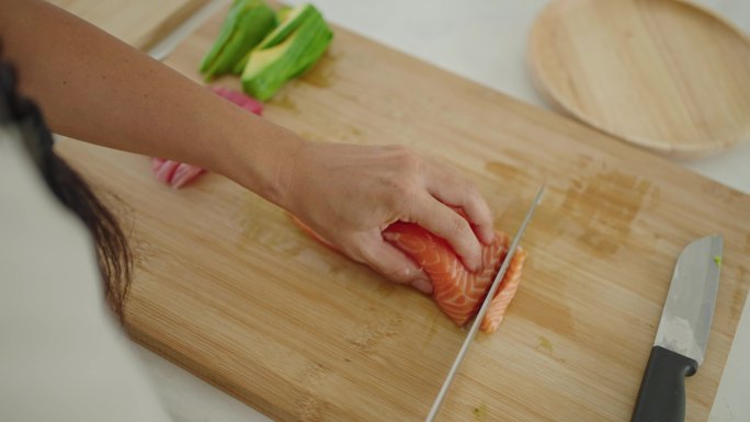 无法辨认的日本裔女性切割鲑鱼