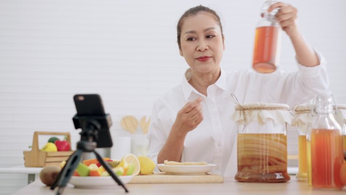 亚洲资深女性影响者，教授如何用不同的调味品制作自制发酵生红茶菌茶。健康的天然益生菌口味饮料，学习使用