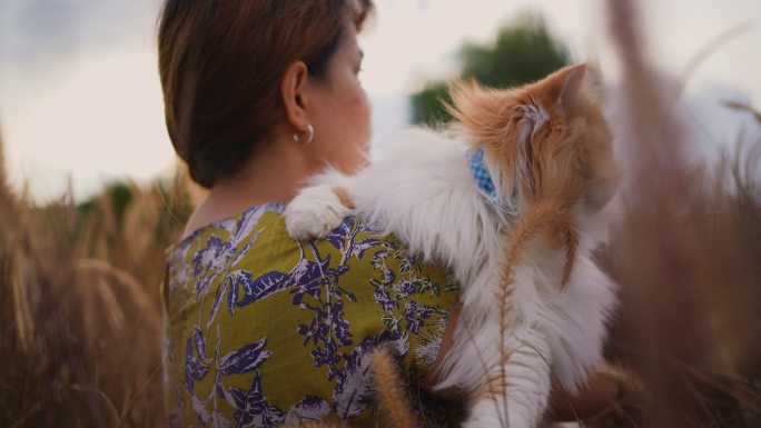 在花园里抱着猫的女人