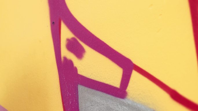 年轻艺术家在橙色墙上涂鸦