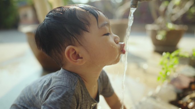 亚洲孩子在户外的水中玩耍