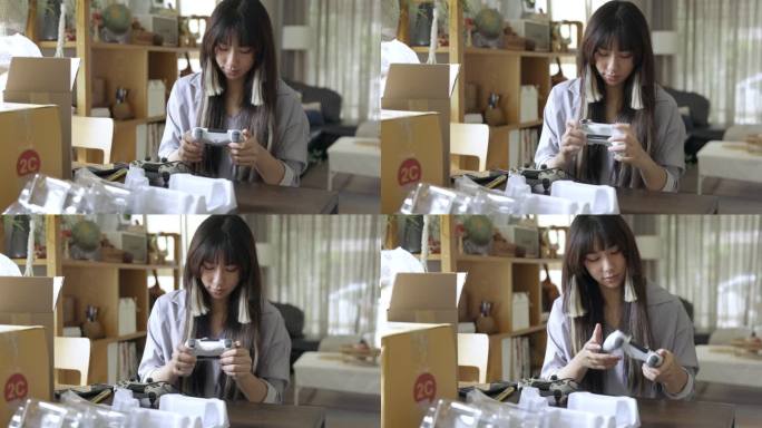 年轻的亚洲女性从网上购物中拆箱产品拍照和检查