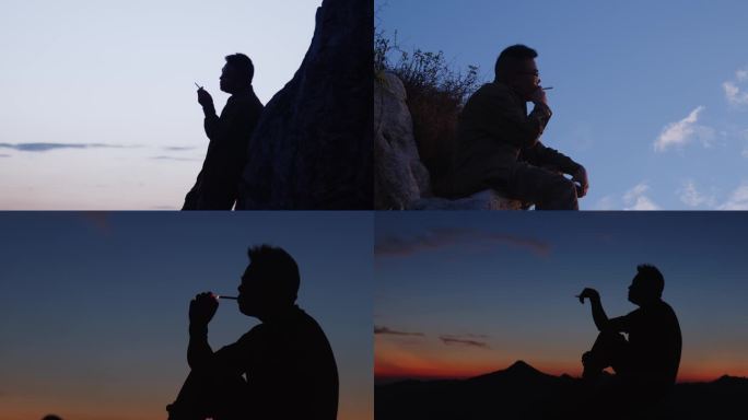 男人坐在山顶孤独抽烟剪影