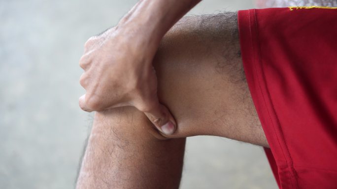 男性使用按摩药丸进行膝盖按摩以缓解疼痛。