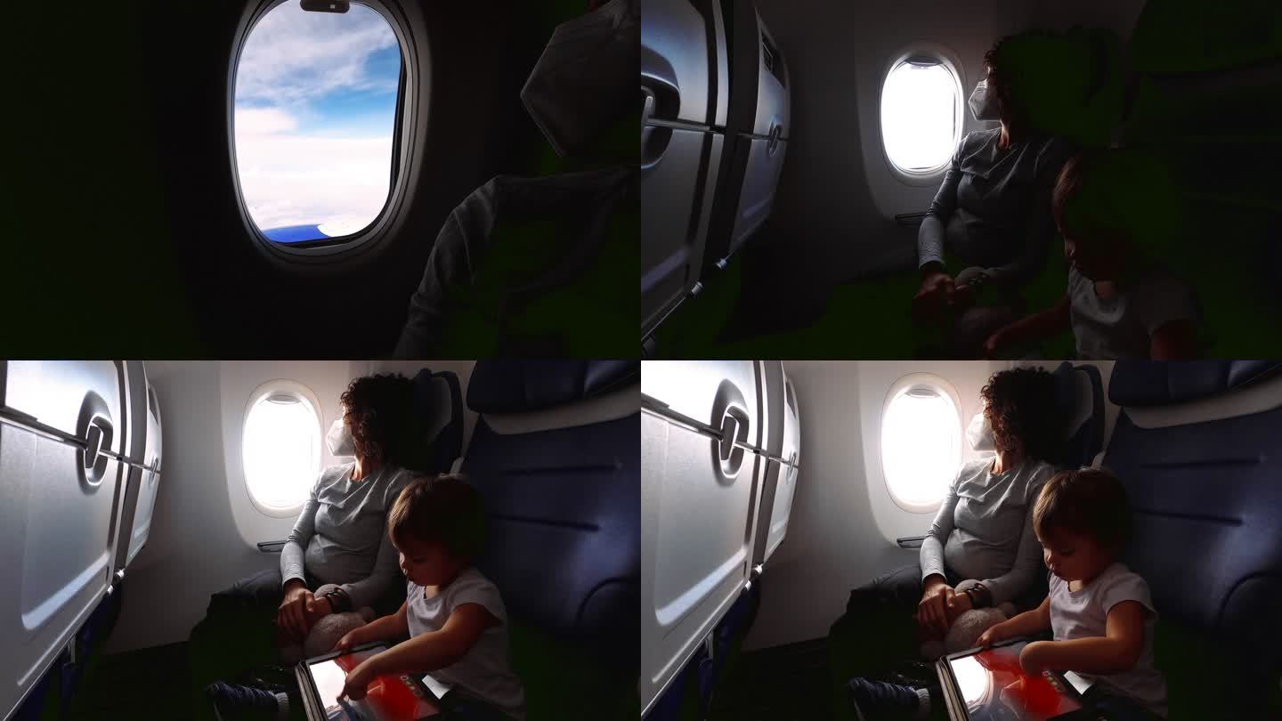 与怀孕妈妈一起乘飞机旅行时使用平板电脑的幼儿
