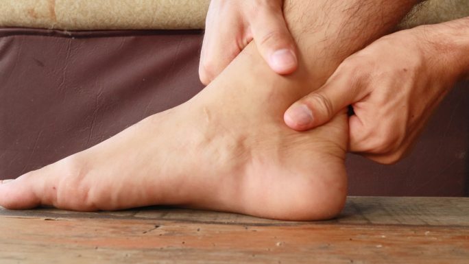酸痛的脚不能行走。用双手按摩脚