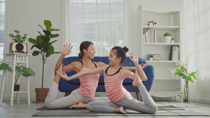 母女俩正在家里练习瑜伽，美人鱼式。